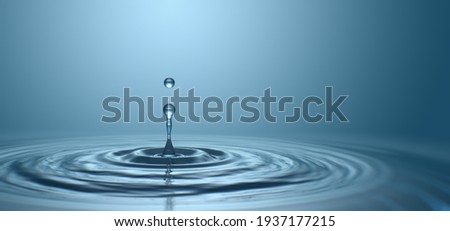 Water drop with droplet and rings on surface bluish background Royalty-Free Stock Photo #1937177215