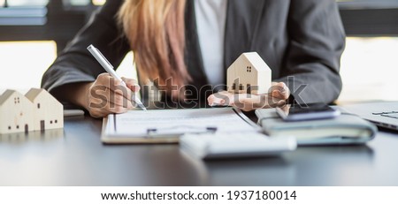 Female woman hands holding home model, small miniature white toy house. Mortgage property insurance dream moving home and real estate concept Royalty-Free Stock Photo #1937180014