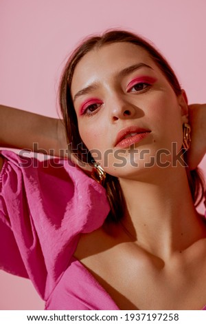 Close up beauty portrait of young beautiful woman with pink, fuchsia color eyeshadow makeup, flawless clean skin. Spring, summer trendy make up