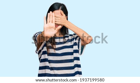 Beautiful young woman wearing casual clothes covering eyes with hands and doing stop gesture with sad and fear expression. embarrassed and negative concept. 