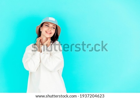 portrait of a beautiful girl in a denim cap and a white hoody on a blue background. concept of sport, summer