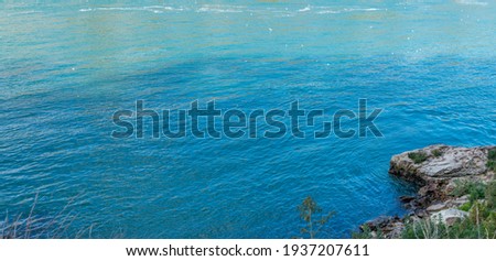 Water surface of a Niagara River near Niagara Falls with a cliff chade on it