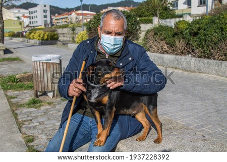 senior man with medical mask protecting himself from coronavirus on the street and his dog