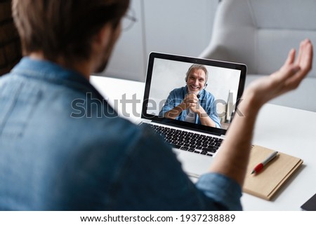Pc screen view over businessman shoulder, due to corona virus all communications, business negotiations Royalty-Free Stock Photo #1937238889