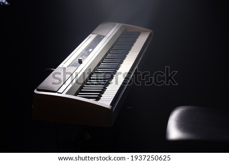 Electric piano keyboard with a spotlight. Live concert stage. Electric instruments