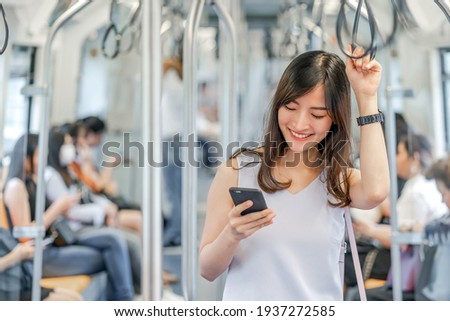Young Asian woman passenger using social network via smart mobile phone in subway train when traveling in big city,japanese,chinese,Korean lifestyle and daily life, commuter and transportation concept Royalty-Free Stock Photo #1937272585