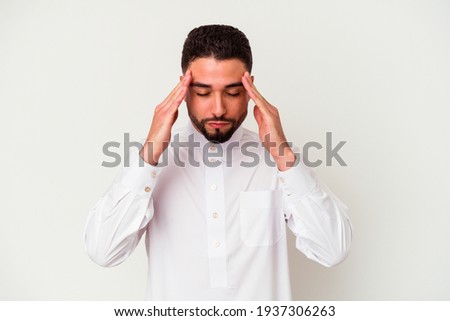 Young arab man wearing typical arab clothes isolated on white background touching temples and having headache. Royalty-Free Stock Photo #1937306263