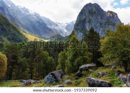 A tourist surrounded by an autumn mountain range. Ossetia Tsey .Mount Monk