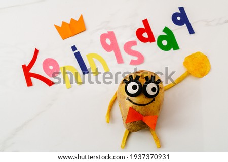 Koningsdag or Kings Day is a national holiday in the Kingdom of the Netherlands. Funny potato with eyes and in a tie on the background of the inscription Koningsdag