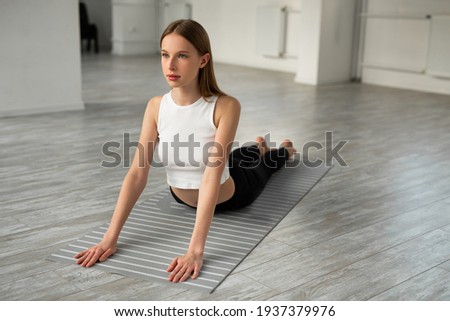 beautiful young woman with a slim figure doing yoga in the gym 