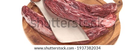 Raw Skirt Steak or Tenderloin Beef Steak and Butcher Hatchet on Cutting Board Isolated on White Background, Overhead View. Uncooked Machete Steak or Bavet Steak On White Background.