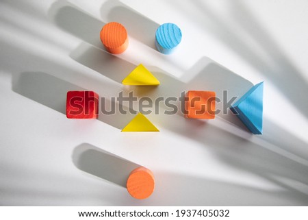 Colorful wooden geometric shapes pattern on white background 