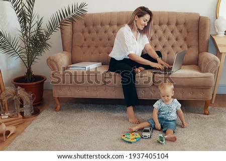 Beautiful business woman working at home. Multi-tasking, freelance and motherhood concept