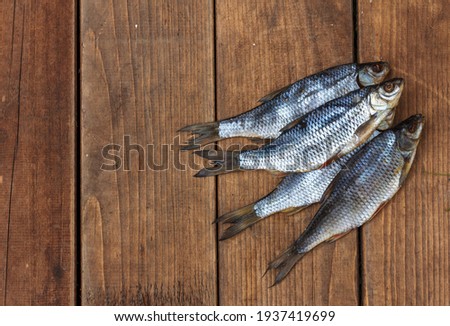 Jerky fish, beer snacks. Dried roach, traditional Russian beer appetizer, on dark wooden boards, top view with space