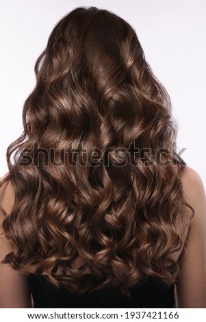 A closeup view of a bunch of shiny curls brown hair Royalty-Free Stock Photo #1937421166