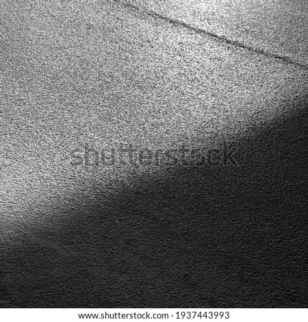 The shadow from the bridge on the paved road