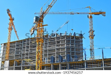 Crane and building under construction against blue sky Royalty-Free Stock Photo #1937456257