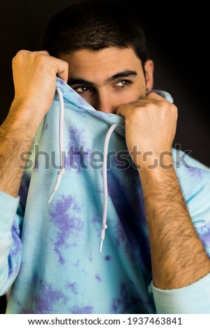 portrait of handsome and young model playing with hoodie