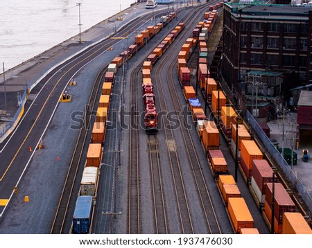 view of a freight train with a red locomotive in between two other freight trains Royalty-Free Stock Photo #1937476030