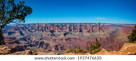 A panoramic view of the Grand Canyon from the south rim showing some of the incredible convolutions the Colorado River has created over millions of years.  An amazing vista under a beautiful blue sky. Royalty-Free Stock Photo #1937476630