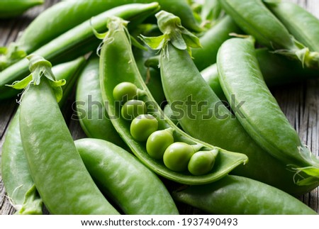 Snap peas placed on an old wooden board. Close-up, image of snap peas. Royalty-Free Stock Photo #1937490493
