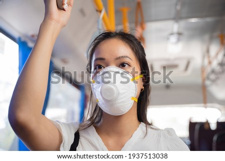 Asian woman Wearing a mask, she's on a public bus