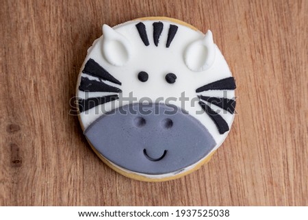 One zebra design iced cookie on a wooden table top  