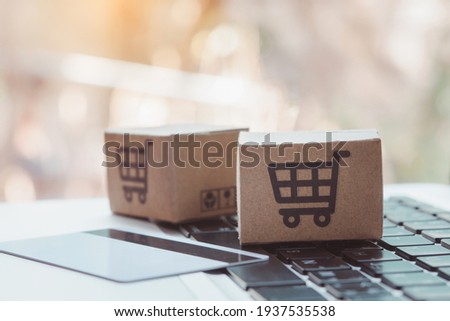Shopping online. Credit card and cardboard box with a shopping cart logo on laptop keyboard. Shopping service on The online web. offers home delivery Royalty-Free Stock Photo #1937535538