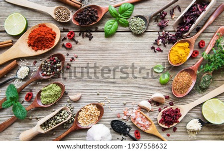 A selection of various colorful spices on a wooden table in  spoons Royalty-Free Stock Photo #1937558632