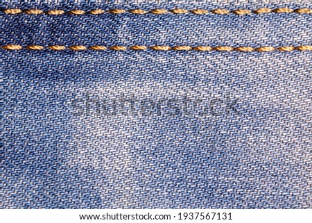 Jeans background. Denim fabric with seams close-up. Royalty-Free Stock Photo #1937567131