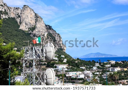 Telecommunications, equipment. A television tower with two white antennas against a background of mountains.