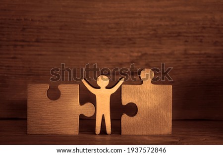 wooden human sign standing between two wooden puzzles. 