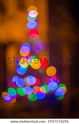Christmas tree of multicolored light circles with bokeh
