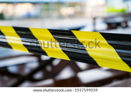 Black and yellow lines of barrier tape forbids passage. Concept of No entry.