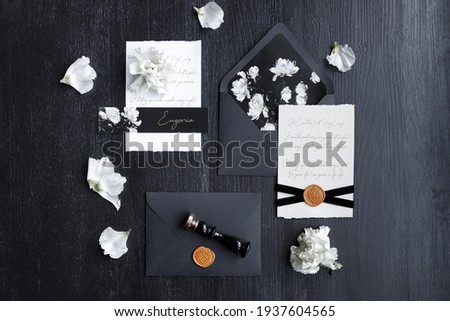 A set of dark wedding printing on a wooden background. Wedding invitation, trendy black background with flower petals.