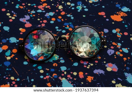 designer glasses with kaleidoscope lenses on abstract background