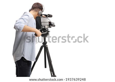 Rear shot of a cameraman recording with a professional camera on a stand isolated on white background Royalty-Free Stock Photo #1937639248