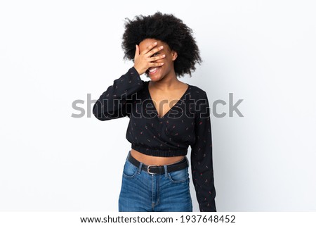 Young African American woman isolated on white background covering eyes by hands and smiling