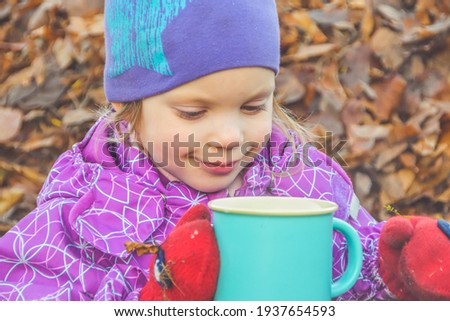 the child lies on the leaves on a Sunny autumn day and is happy