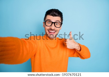Photo of young excited brown hair man happy make selfie show thumb-up cool perfect isolated over blue color background