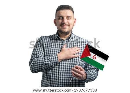 White guy holding a flag of Western Sahara and holds his hand on his heart isolated on a white background With love to Western Sahara.