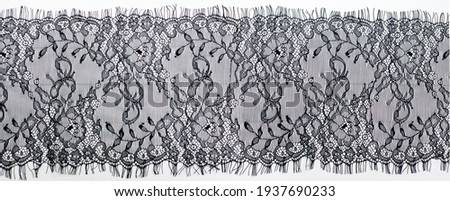 Black lace on a white background. black lace trim around the yard. fabric for underwear. crochet trim. your design. postcard invitation. texture background pattern. Panoramic photography