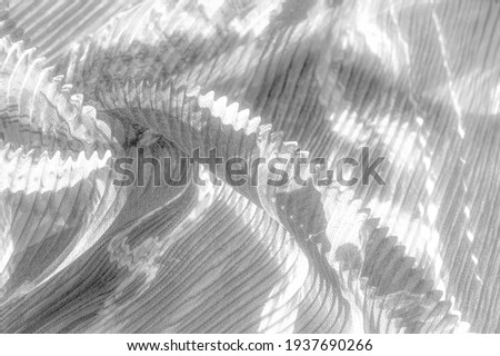 corrugated silk. Platinum gray and white colors. Ruffled silk fabric in vintage style. Floral pattern for elasticity. Gives pleats and pleats to the gathered fabric.