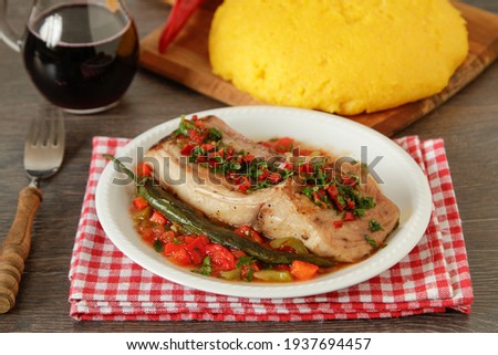 Mediterranean baked fish fillets with tomato sauce and hot peppers
