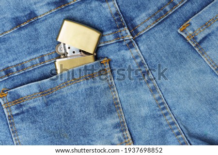 Lighter in the back pocket of jeans, habit in your pocket every day, jeans texture close-up