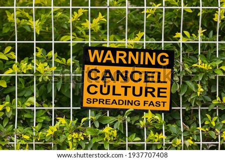 Black and yellow warning sign on a fence stating "Warning, cancel culture spreading fast". Royalty-Free Stock Photo #1937707408