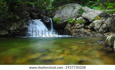 Small cascade on Lotru River near its spring. Water flowing along a huge boulder. Alpine landscape in Parang Mountains, Carpathia, Romania
 Royalty-Free Stock Photo #1937730208