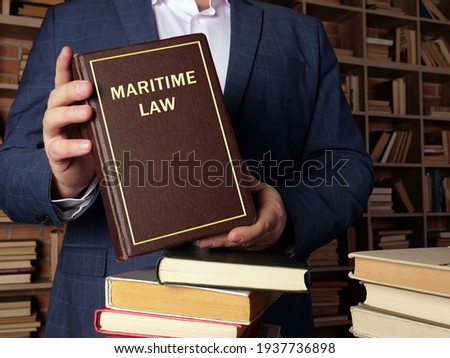  MARITIME LAW book in the hands of a jurist. Maritime law, also known as admiralty law, is a body of laws, conventions. Royalty-Free Stock Photo #1937736898