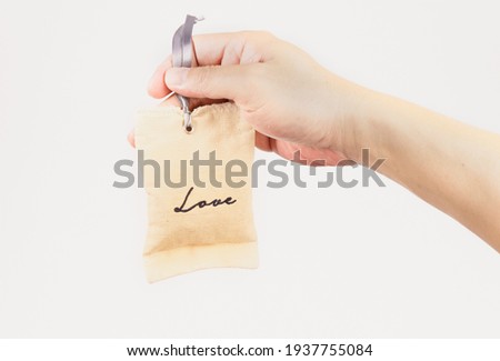 People show the word of love on the small bag for love of a couple