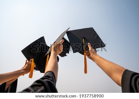 graduates student Graduation caps thrown in the Air Blue sky Royalty-Free Stock Photo #1937758900